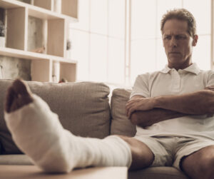 man sitting on couch with case on leg