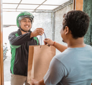 food delivery driver handing customer bag