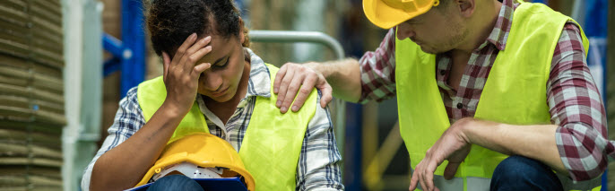 male coworker with hand on shoulder of a female worker in a warehouse