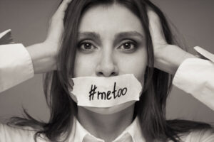 black and white photo of a woman with tape on her mouth with #metoo in writing on the tape