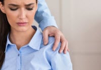 male employer touching female employees shoulder