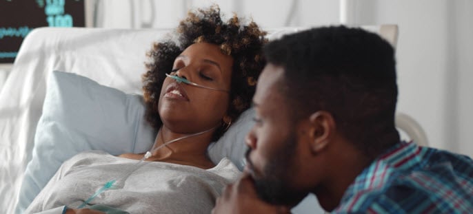 husband worried about wife in hospital bed