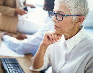 older professional female worker looking at computer
