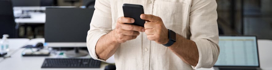businessman holding smartphone picking a GIF to send to a coworker